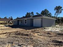 Newly constructed home with gray exterior, attached garage, and unfinished landscaping at 15805 Sw 37Th Cir, Ocala, FL 34473