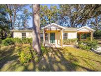 One-story house with covered porch, landscaping, and a large tree in the front yard at 5213 Se 114Th St, Belleview, FL 34420