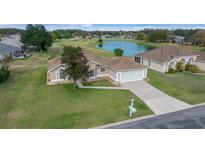 Aerial view of a house with a golf course and lake in the background at 5065 Nw 21St Loop, Ocala, FL 34482