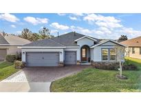 Single-story home with gray siding, stone accents, and a two-car garage at 3480 Nw 55Th Ct, Ocala, FL 34482