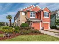 Two-story townhome with two-toned exterior, attached garage, and landscaped yard at 4950 Sw 45Th Cir, Ocala, FL 34474