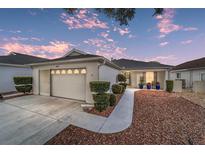 Inviting exterior featuring a two-car garage and well-manicured landscaping at 9088 Sw 95Th Ave, Ocala, FL 34481