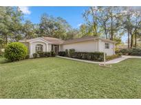 Single-story home with landscaped lawn and walkway at 9593 Sw 196Th Avenue Rd, Dunnellon, FL 34432