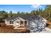 Charming two-story home with a gray exterior, white trim, and a two-car garage at 4678 Sw Evergreen Ct, Dunnellon, FL 34431