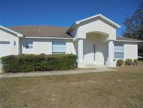 Front exterior of a single-story home with a covered entryway and landscaping at 4725 Sw 100Th St, Ocala, FL 34476