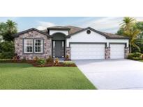 Inviting single-story home with a three-car garage and stone accents at 3095 Canopy Oak Blvd, Wildwood, FL 34785