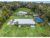 Aerial view of a home with pool, barn, and expansive land at 3505 Ne 97Th Street Rd, Anthony, FL 32617