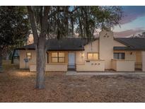 Charming two-story home with stucco exterior and attached one-car garage at 56 Pine Trak # 101E, Ocala, FL 34472