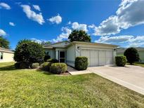 Single-story home with a two-car garage and well-maintained landscaping at 15570 Sw 13Th Cir, Ocala, FL 34473