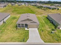 Aerial view of a single-Gathering home with a two-car garage and well-manicured lawn at 6243 Sw 89Th Street Rd, Ocala, FL 34476