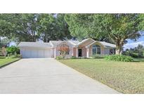 Cute ranch home with attached two-car garage and well-manicured lawn at 8225 Sw 108Th Loop, Ocala, FL 34481