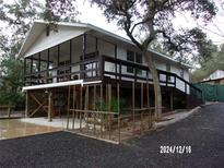 Elevated home with wraparound porch, screened deck, and spacious parking area at 17935 Se 10Th Pl, Silver Springs, FL 34488