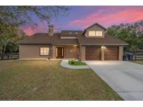 Two-story house with brown exterior, two-car garage, and a well-manicured lawn at 21959 Nw 6Th St, Dunnellon, FL 34431