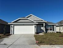 New single-story home with gray siding, white garage door, and landscaping at 4445 Sw 90Th Pl, Ocala, FL 34476