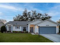 White house with blue garage door, landscaping, and a spacious lawn at 4707 River Ridge Dr, Leesburg, FL 34748
