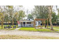 Charming white cottage with a spacious yard, pergola, and patio at 2751 Ne 46Th St, Ocala, FL 34479