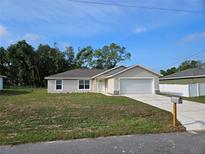 Newly constructed home with a two-car garage and landscaped lawn at 174 Pine Crse, Ocala, FL 34472