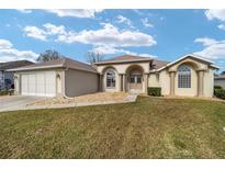 House exterior showcasing a two-car garage and well-maintained lawn at 2462 Nw 53 Ave Rd, Ocala, FL 34482