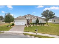 One-story home with stone accents, landscaping, and a two-car garage at 6407 Sw 45Th Ave, Ocala, FL 34474