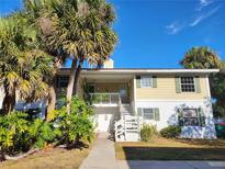 Exterior view of a two-story condo building with lush landscaping and palm trees at 8128 Fairways Cir # R101, Ocala, FL 34472