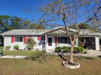 Charming single story home with red shutters and a well-manicured lawn at 8473 Sw 106Th St, Ocala, FL 34481