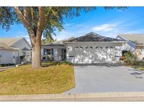 White one-story house with a two-car garage and landscaping at 9158 Sw 91St Ter, Ocala, FL 34481