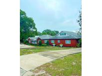 Brick house with a long driveway and large lawn at 1200 W Lake Otis Se Dr, Winter Haven, FL 33880