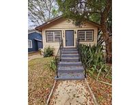 Charming one-story house with gray steps and landscaping at 1414 Johns Ave, Haines City, FL 33844
