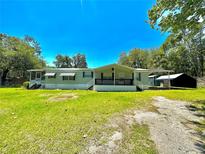 Single-wide manufactured home with covered porch and large yard at 5490 Morgan Rd, Lakeland, FL 33810