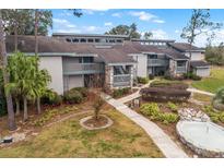 Exterior of a condo building, showing landscaping, walkways, and a small fountain at 2070/2071 Corner Lake Dr # 2, Haines City, FL 33844