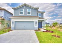Two story home with gray siding and two car garage at 1409 Leamington Ln, Winter Haven, FL 33884