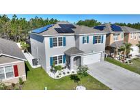 Two-story home with solar panels, a landscaped yard, and a welcoming front porch at 856 Sun Burst Rd, Winter Haven, FL 33880
