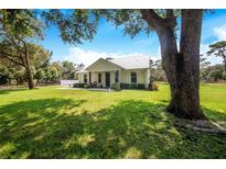 Charming farmhouse with metal roof, large yard, and covered porch at 12510 Lake Hatchineha Rd, Haines City, FL 33844