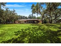 Single-story home with a large backyard and mature trees at 8881 Cypresswood Dr, Lake Wales, FL 33898