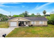 Brick ranch house with attached garage, driveway, and large yard at 329 N 19Th St, Haines City, FL 33844