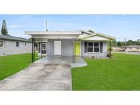 Gray house with a green door and carport at 2020 Bassedena W Cir, Lakeland, FL 33805