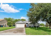 Charming single-story home with a two-car garage and mature landscaping at 4353 Dinner Lake Dr, Lake Wales, FL 33859