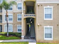 Exterior view of condo building with stairs and landscaping at 8105 Coconut Palm Way # 204, Kissimmee, FL 34747