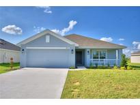 Newly constructed home with gray exterior, two-car garage, and landscaped lawn at 4065 Tullamore Ln, Auburndale, FL 33823