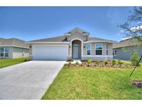 Single-story home with attached garage and landscaping at 1269 Tagliamento Ln, Haines City, FL 33844