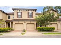 Tan three-unit townhouse with two-car garages and landscaping at 8153 Roseville Rd, Davenport, FL 33896