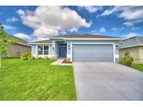 Single-story house with gray siding, two-car garage, and a manicured lawn at 502 Tanaro Ln, Haines City, FL 33844