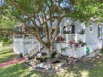 Charming house with wrap-around porch, landscaping, and pond feature at 319 N Wales Dr, Lake Wales, FL 33853