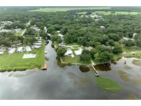 Aerial view of waterfront property with a canal, dock, and pool at 3200 Citrus Ct, Lake Wales, FL 33898