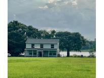 Two-story house on a lakefront property with green lawn at 915 C F Kinney Rd, Lake Wales, FL 33859