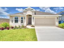 Charming one-story house with a two-car garage and well-manicured lawn at 1222 Tagliamento Ln, Haines City, FL 33844