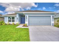 Single-story home with gray exterior, two-car garage, and landscaped lawn at 1218 Tagliamento Ln, Haines City, FL 33844