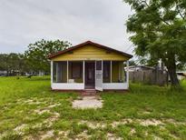 Small yellow house with screened porch at 1510 W Derby Ave, Auburndale, FL 33823