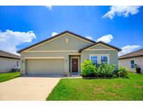One-story house with green exterior, two-car garage, and landscaping at 4850 St James Ct, Winter Haven, FL 33881