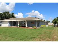 Ranch-style home with gray brick exterior and covered porch at 6750 Winterset Gardens Rd, Winter Haven, FL 33884